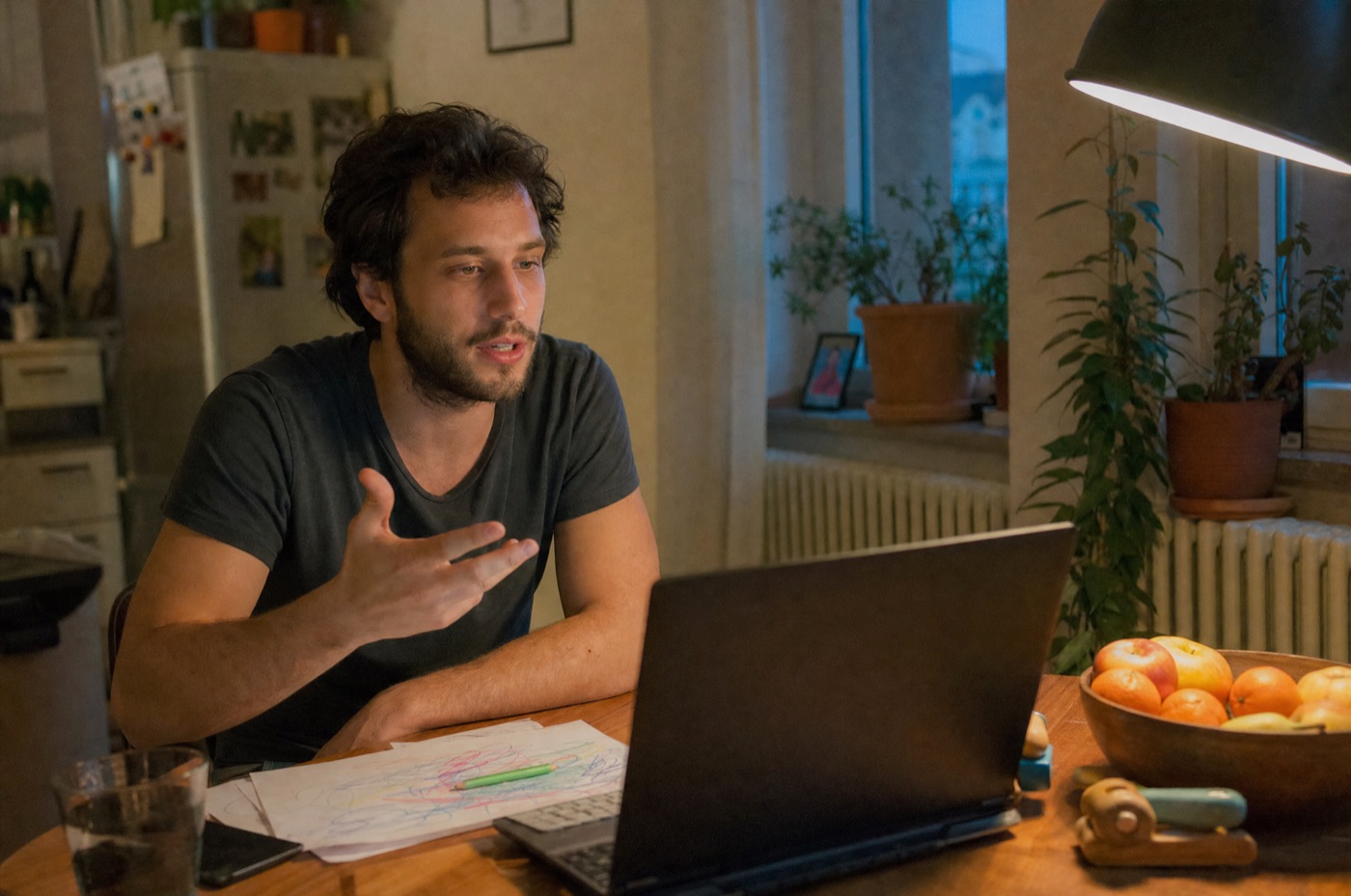 Mann diktiert abends am Küchentisch in seinen Laptop